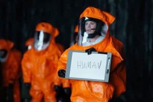 Scene from the film Arrival, depicting scientist holding a sign that says 'HUMAN'