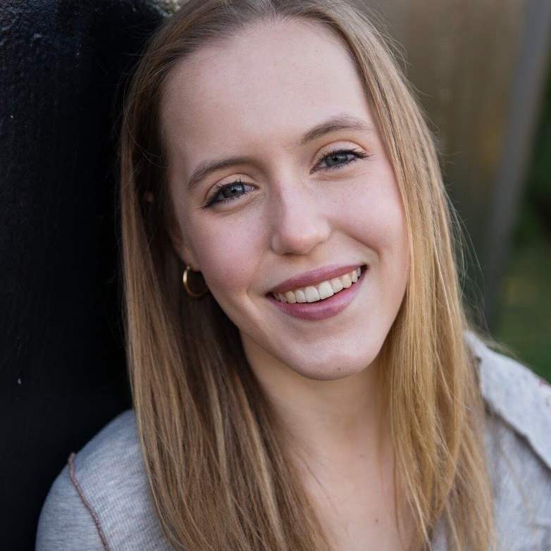 photograph of Rebecca Flack in front of a black wall